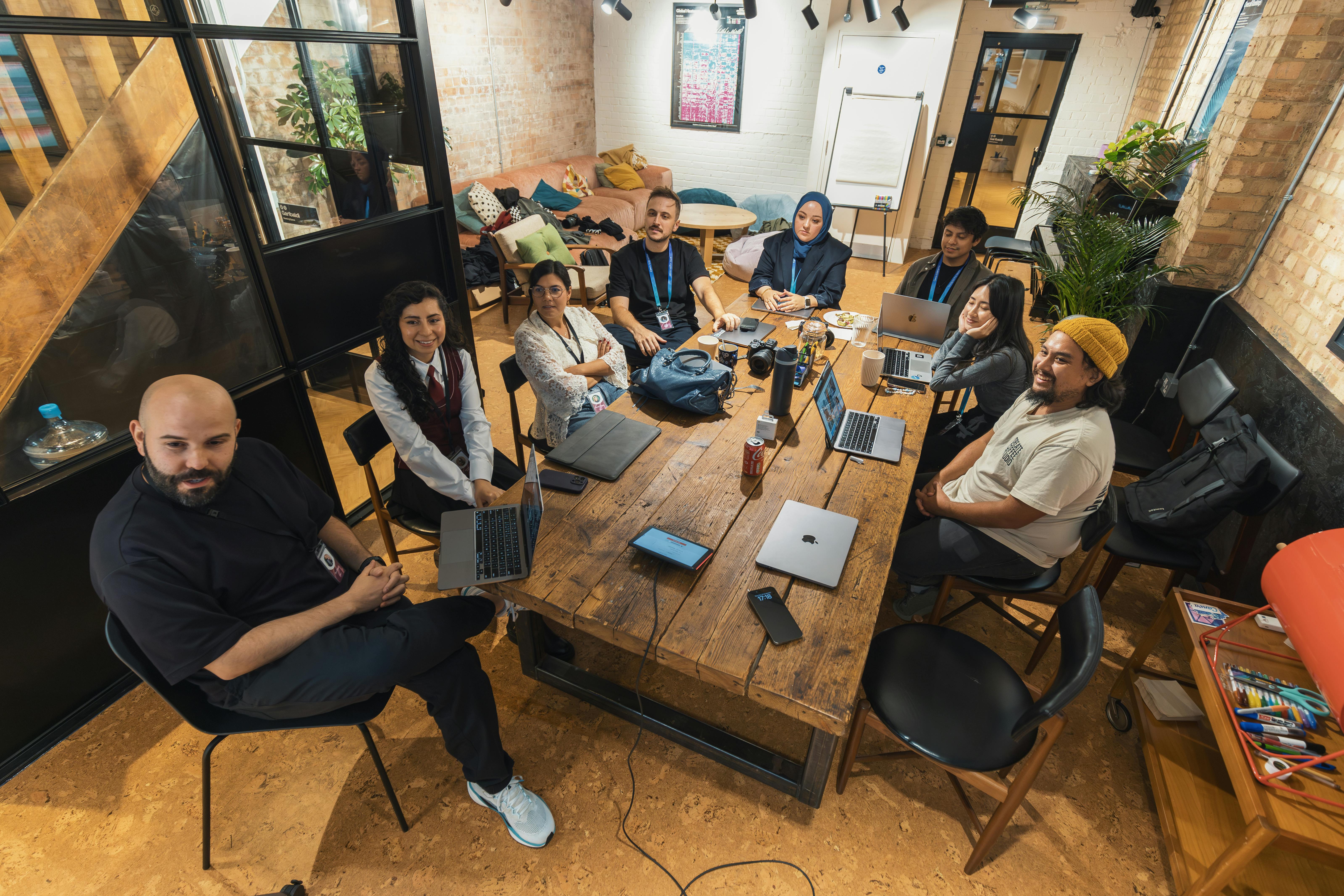 Equipe reunida em sala de reunião com laptops